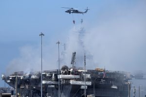 Helicopters and ships work to control fire